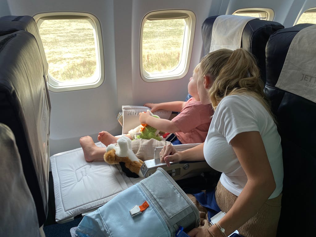 A Woman and a Young Boy in an Airplane - The Explore Horizon