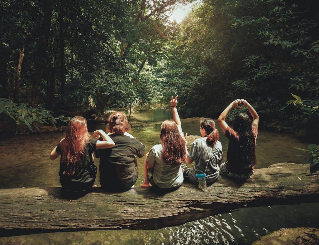 Five Women Sitting On Tree Trunk